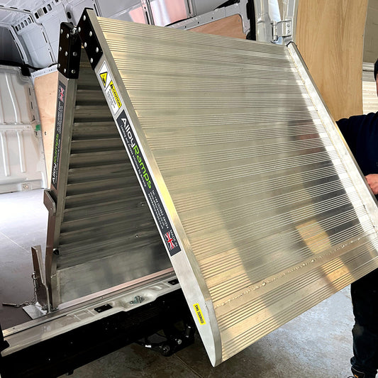 Picture of a folding van ramp folded half way. Fixed folding van ramp fitted to a van.